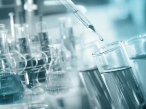 A scientist is pouring liquid into a beaker.