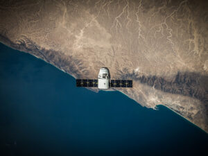 An aerial view of a spacecraft flying over the ocean.